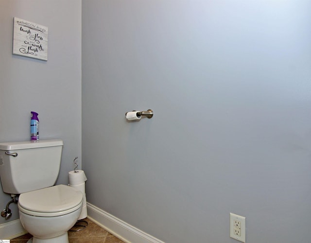 bathroom with tile patterned flooring, baseboards, and toilet