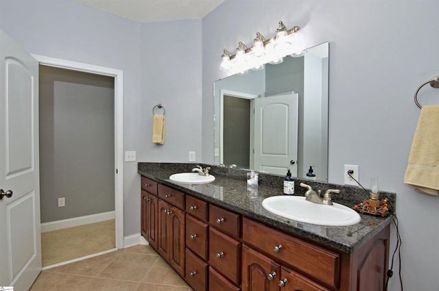 bathroom featuring a sink, tile patterned floors, double vanity, and baseboards
