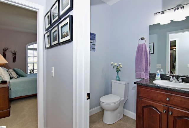 ensuite bathroom with vanity, ensuite bath, tile patterned flooring, toilet, and baseboards