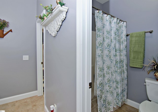 bathroom with toilet, tile patterned floors, a shower with curtain, and baseboards