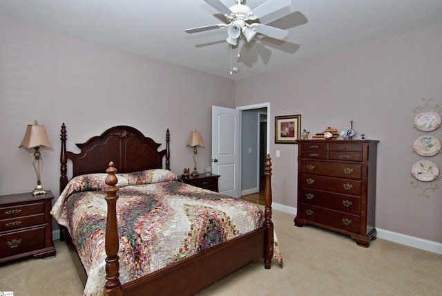 bedroom featuring light colored carpet, ceiling fan, and baseboards