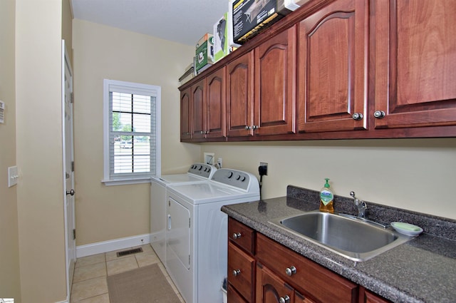 laundry room featuring separate washer and dryer, light tile patterned flooring, visible vents, cabinet space, and a sink