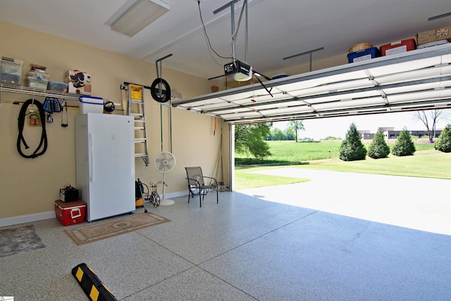 garage featuring a garage door opener, freestanding refrigerator, and baseboards