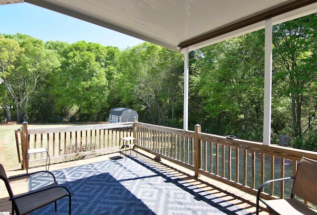 wooden deck with a storage shed and an outdoor structure