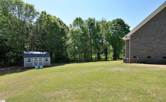 view of yard with central air condition unit, a storage unit, and an outdoor structure