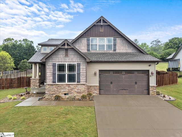 craftsman house featuring a front yard, a shingled roof, stone siding, a garage, and fence