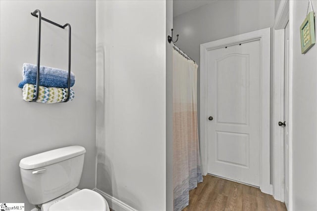 bathroom with toilet and wood finished floors