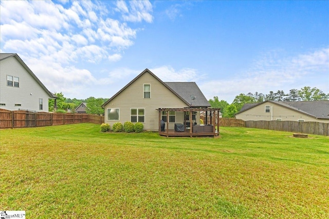 rear view of house featuring a yard, a fenced backyard, a wooden deck, and a pergola