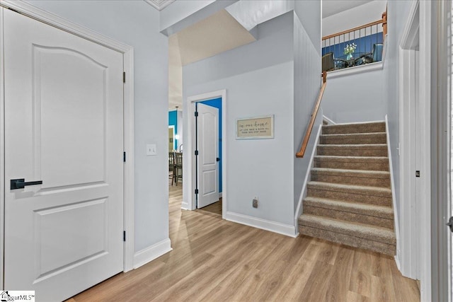 stairway featuring wood finished floors and baseboards