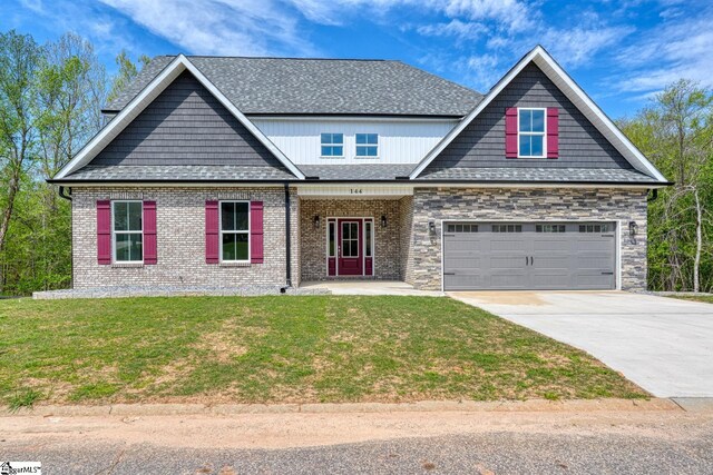 craftsman-style house with concrete driveway, a front yard, a garage, and a shingled roof