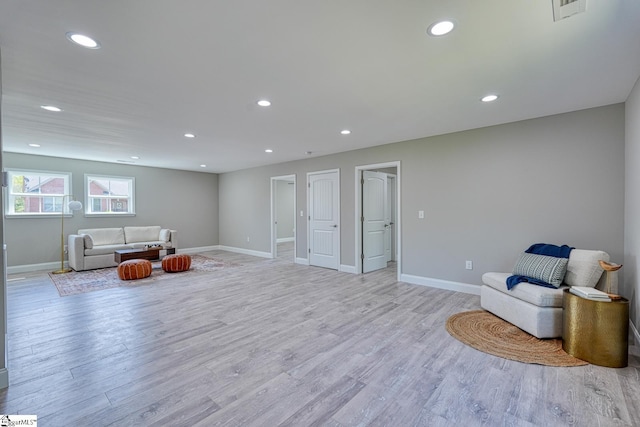 living area featuring light wood-style floors, baseboards, visible vents, and recessed lighting
