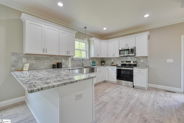 kitchen featuring white cabinets, light stone counters, a peninsula, and stainless steel appliances