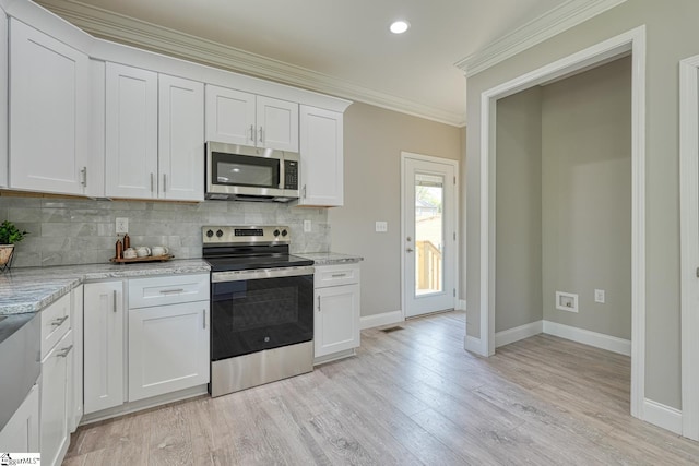 kitchen with tasteful backsplash, baseboards, ornamental molding, and appliances with stainless steel finishes