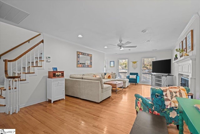 living area featuring light wood-style flooring, ornamental molding, stairway, and recessed lighting