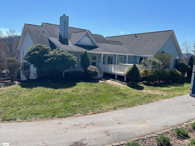 view of front of property with a chimney and a front lawn
