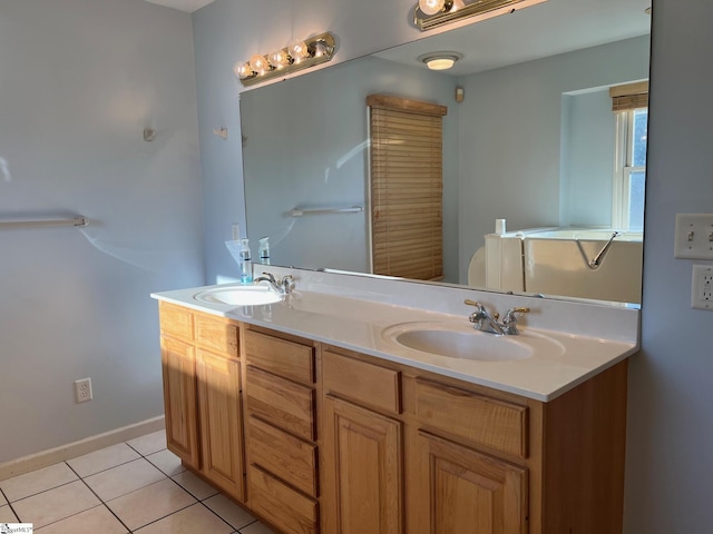 full bathroom featuring a sink, tile patterned floors, double vanity, and baseboards