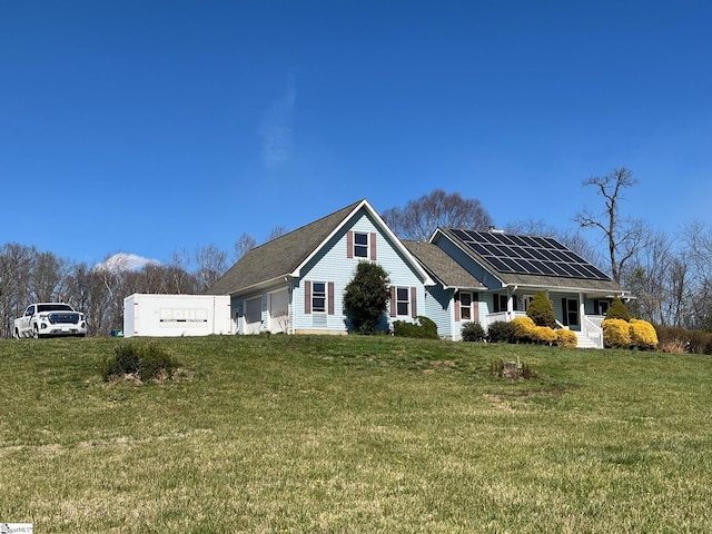 single story home featuring a front yard and solar panels