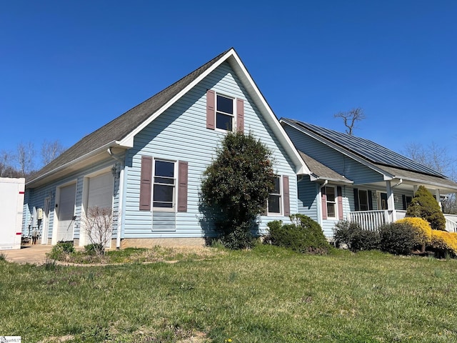 view of side of home with a porch, a garage, and a lawn