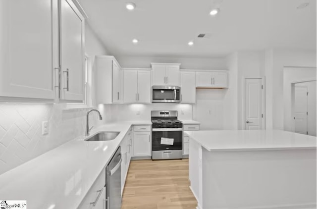 1031 Whitefox Dr Lot 53, Spartanburg, SC 29307 - kitchen featuring light wood-style floors, appliances with stainless steel finishes, a sink, and white cabinetry