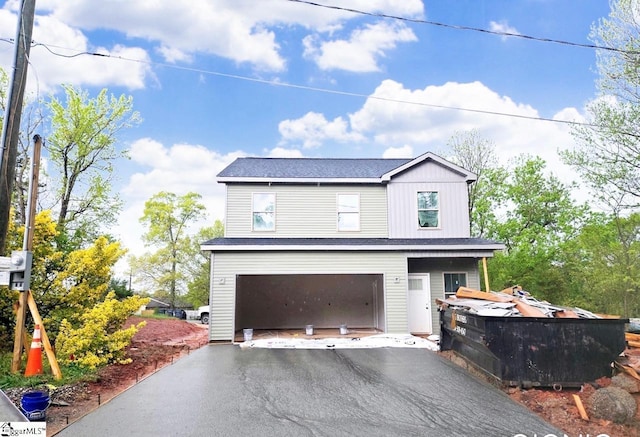 view of front of house featuring aphalt driveway, roof with shingles, and a garage