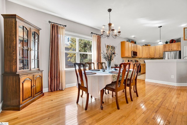 dining area featuring light wood-style flooring, a notable chandelier, baseboards, and recessed lighting