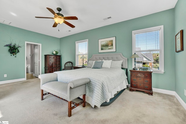 carpeted bedroom with visible vents, baseboards, and a ceiling fan