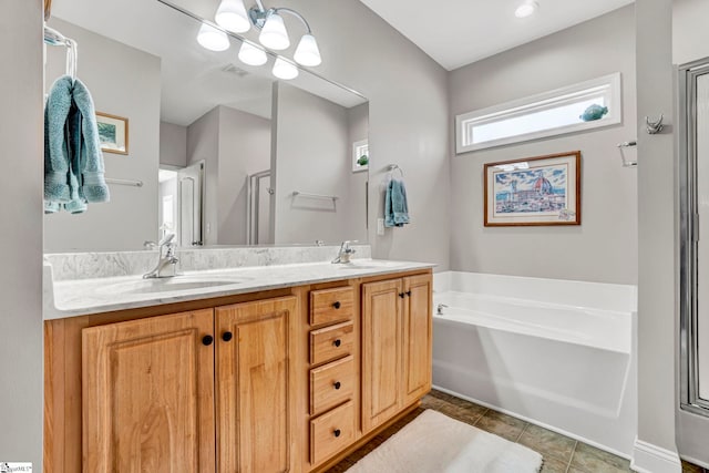 bathroom with a sink, tile patterned floors, a bath, and double vanity