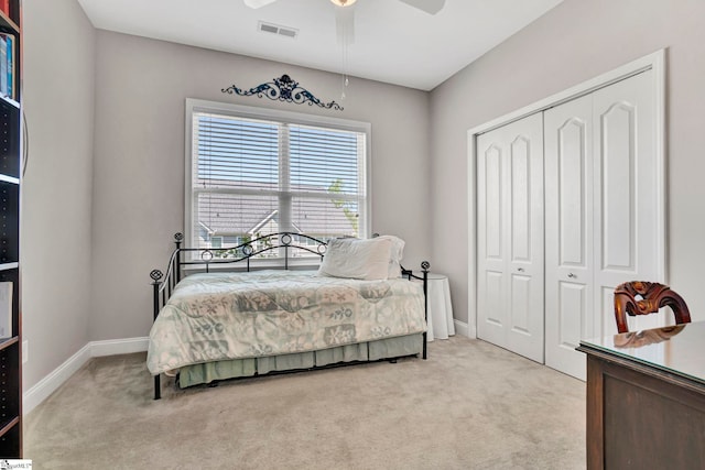 bedroom featuring ceiling fan, a closet, visible vents, light carpet, and baseboards