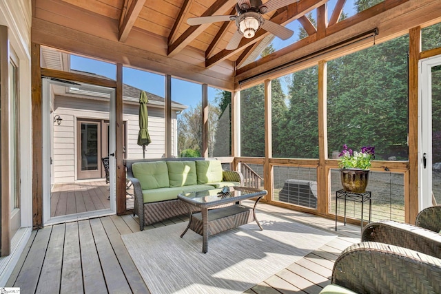 sunroom with a wealth of natural light, beamed ceiling, outdoor lounge area, and a ceiling fan