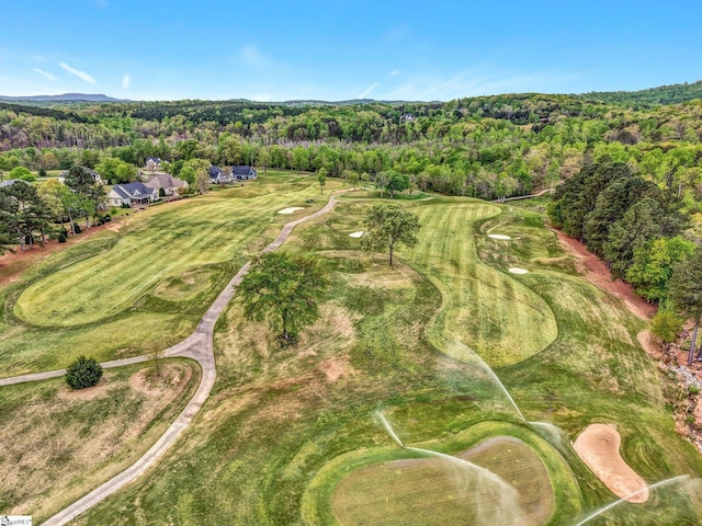 drone / aerial view with a wooded view and golf course view