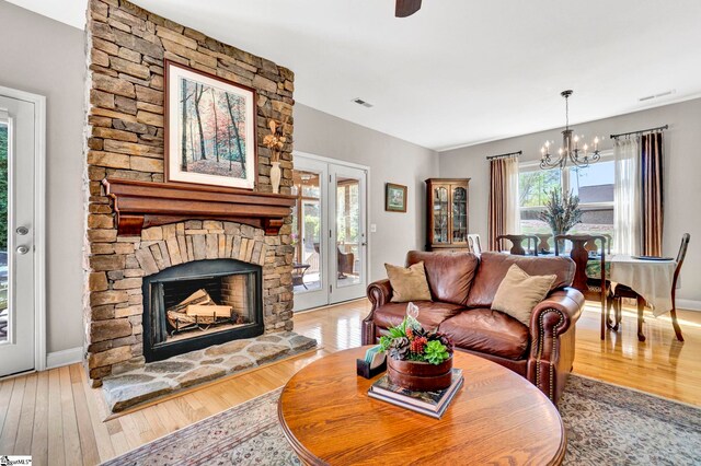 living area with hardwood / wood-style floors, a notable chandelier, and visible vents