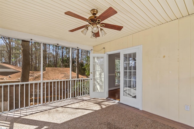 unfurnished sunroom featuring ceiling fan