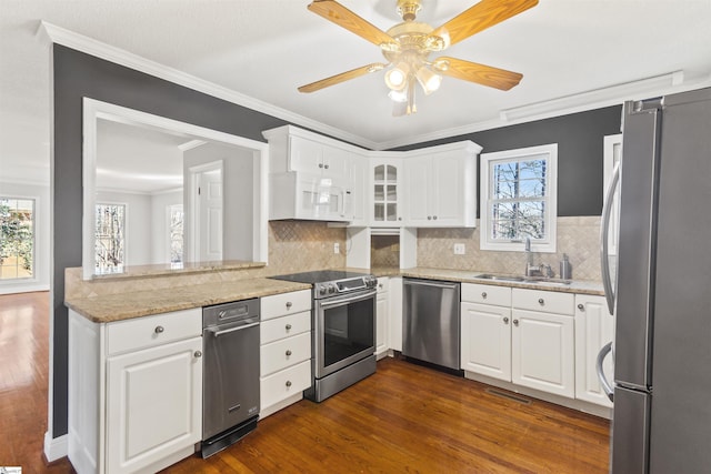 kitchen with stainless steel appliances, dark wood-style flooring, white cabinetry, and a sink