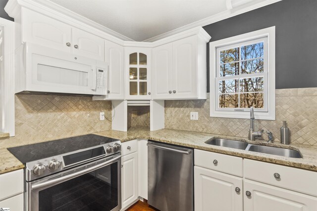 kitchen featuring a sink, decorative backsplash, appliances with stainless steel finishes, and white cabinetry