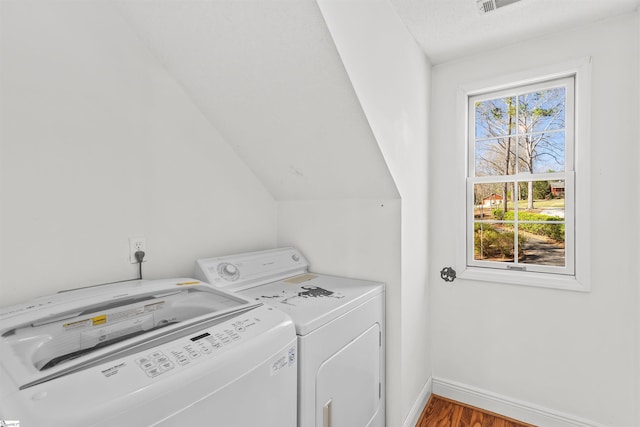 laundry area featuring baseboards, laundry area, washing machine and clothes dryer, and wood finished floors