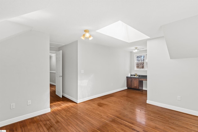 bonus room featuring wood-type flooring, baseboards, and a skylight