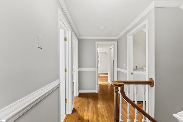 hall with light wood-style floors and crown molding