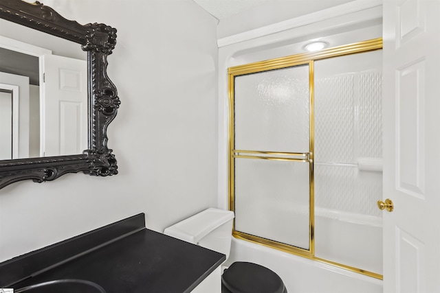 bathroom with toilet, vanity, and shower / bath combination with glass door