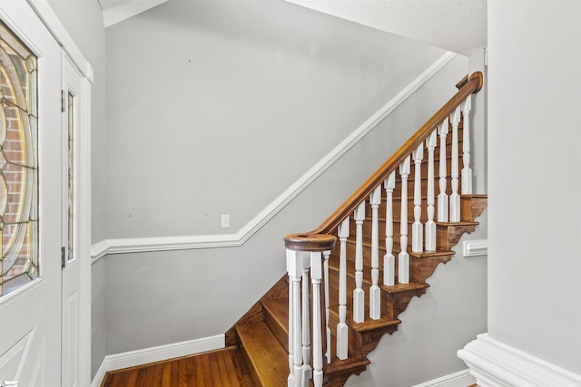 stairs featuring wood finished floors and baseboards
