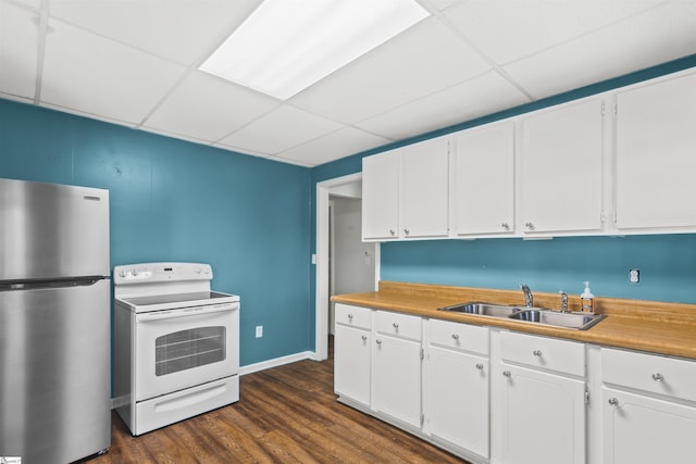 kitchen featuring white electric range, freestanding refrigerator, a drop ceiling, white cabinets, and a sink