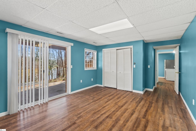 unfurnished bedroom with access to exterior, visible vents, a drop ceiling, and baseboards