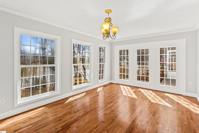 unfurnished sunroom with french doors and an inviting chandelier