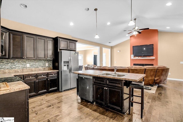 kitchen featuring a sink, ceiling fan, appliances with stainless steel finishes, light wood finished floors, and vaulted ceiling