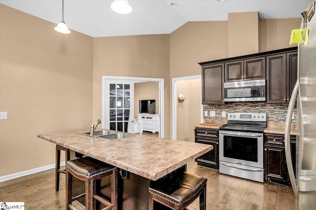 kitchen featuring light wood-style floors, light countertops, a sink, and appliances with stainless steel finishes