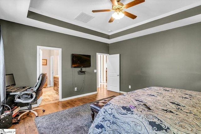 bedroom featuring visible vents, baseboards, ornamental molding, and wood finished floors