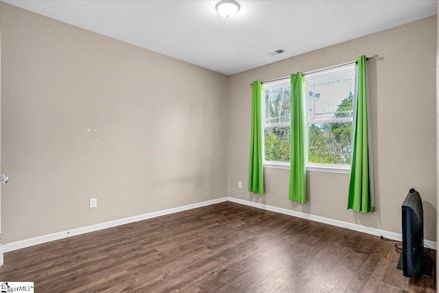 unfurnished living room featuring wood finished floors, baseboards, and visible vents