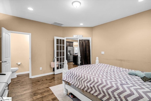 bedroom with ensuite bathroom, visible vents, recessed lighting, dark wood-style flooring, and stainless steel fridge