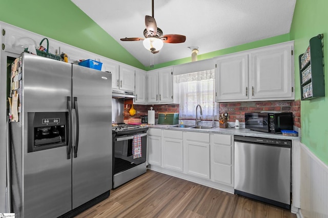 407 Rotterdam Rd, Easley, SC 29640 - kitchen with white cabinets, a sink, under cabinet range hood, stainless steel appliances, and lofted ceiling