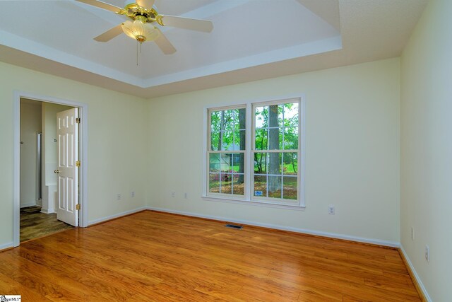15 Red Cedar Ct, Simpsonville, SC 29681 - empty room with visible vents, light wood-style flooring, a tray ceiling, and ceiling fan