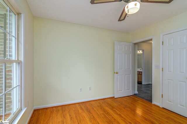 15 Red Cedar Ct, Simpsonville, SC 29681 - unfurnished bedroom featuring light wood-style floors, multiple windows, baseboards, and ceiling fan